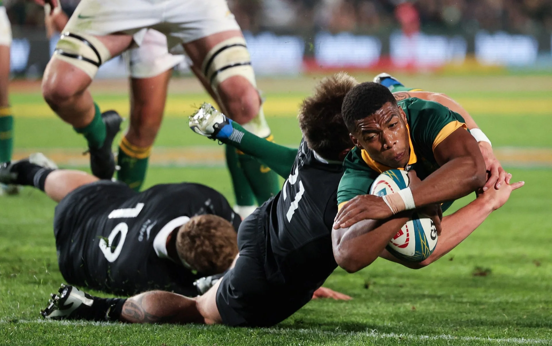 Springbok diving for a try against All Black defenders